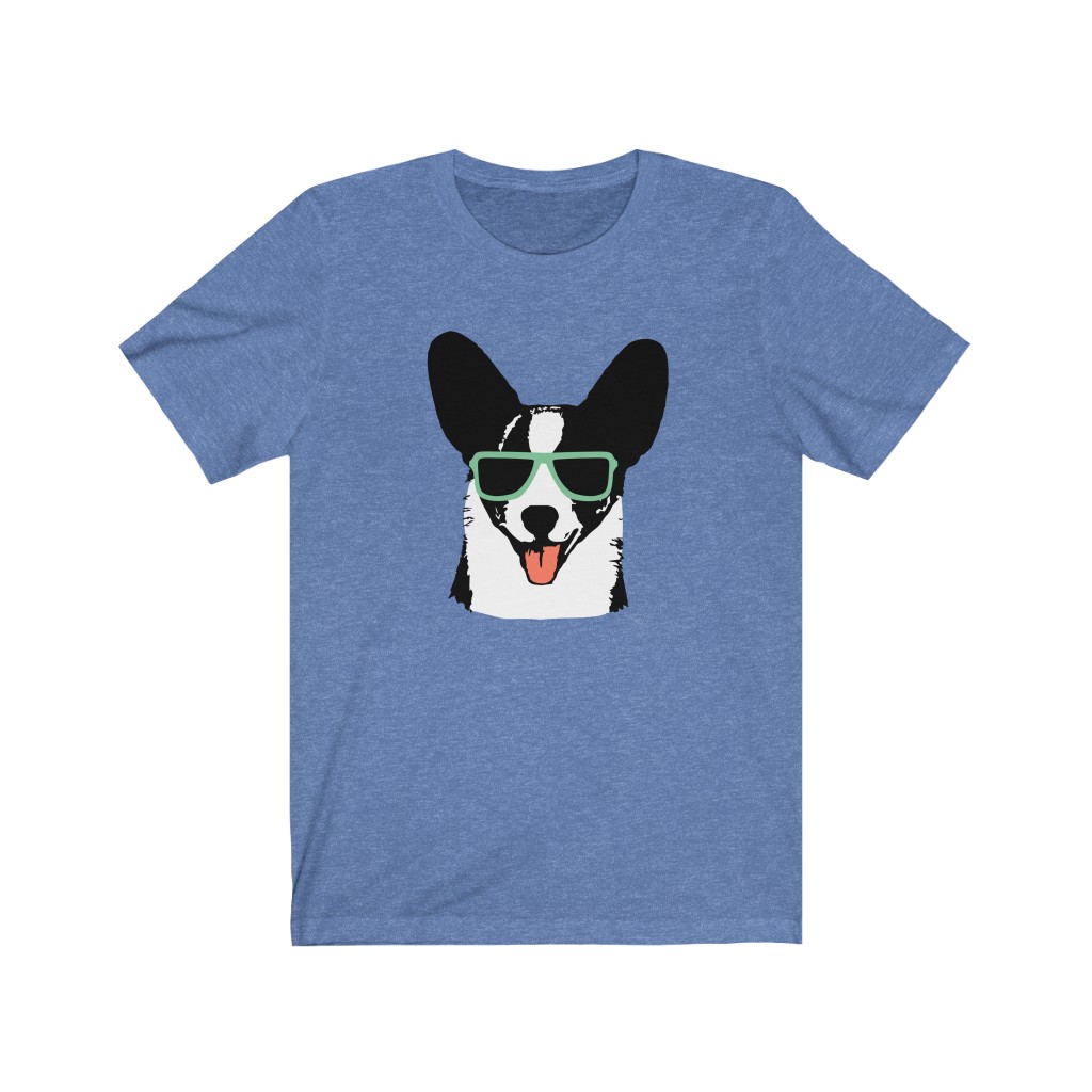 An original Cardi Hardy short sleeve tshirt. Medium blue with Cardi Hardy logo, a Cardigan corgi wearing sunglasses and sticking his tongue out